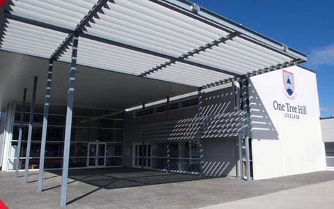 School building exterior with a covered entrance walkway and branded signage