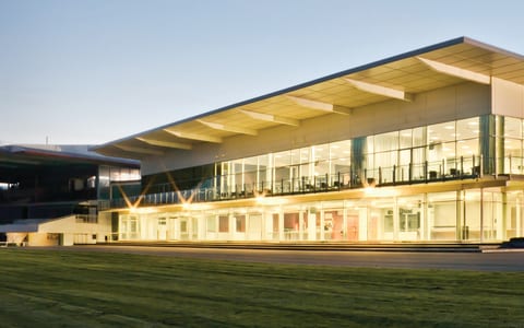 Large modern function centre building with full-length glazing, illuminated at dusk