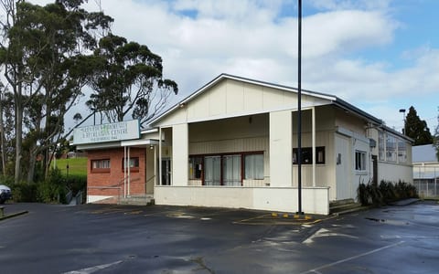 Cream and brick community and recreation centre building with car park