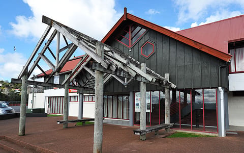 Dark timber function centre with timber post portico and red metal roof