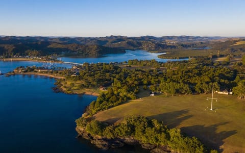 Aerial view of Waitangi Treaty Grounds on a bay peninsula surrounded by water and trees