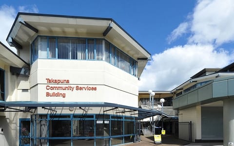Two-storey community services building with signage, courtyard entrance, and covered walkway