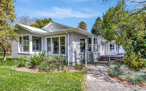 Single-storey weatherboard building with garden surrounds and entry steps