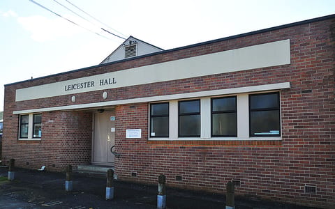 Brick hall building with Leicester Hall signage and car park