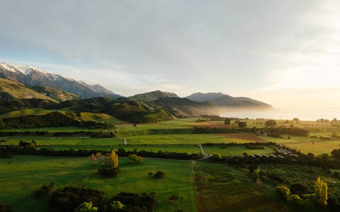 Aerial view of rural valley with farmland, mountains, and coastline