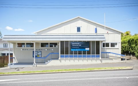 Single-storey community hall with signage on roadside frontage