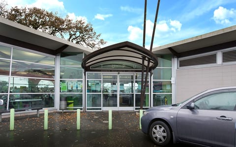 Low-rise library building entrance with glass frontage and covered entry