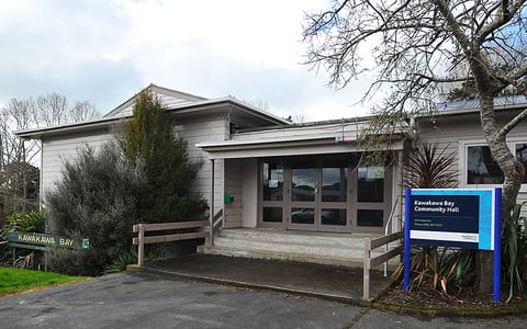Low-set community hall exterior with car park and signage
