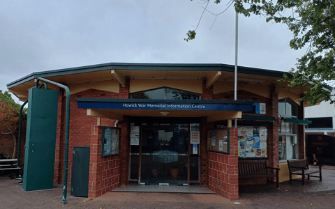 Brick community hall building with covered entry, Howick War Memorial Information Centre signage