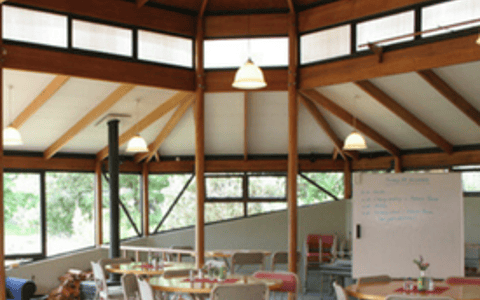 Octagonal timber meeting room with tables, chairs, and whiteboards, labelled Meeting spaces