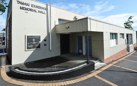 Single-storey hall building exterior with signage and car park