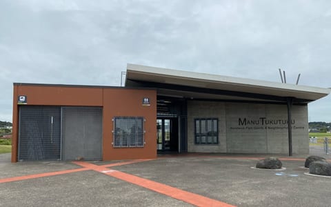 Single-storey sports and community centre with terracotta and concrete facade