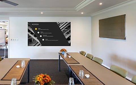 Meeting room with U-shaped table arrangement and presentation screen