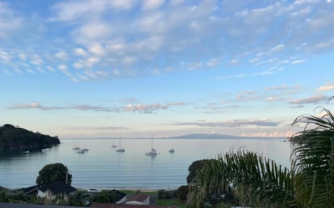 Coastal view with moored sailboats on calm water at dusk