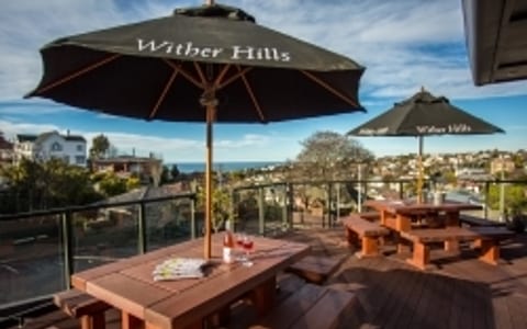Rooftop deck with outdoor tables, umbrellas, and harbour views