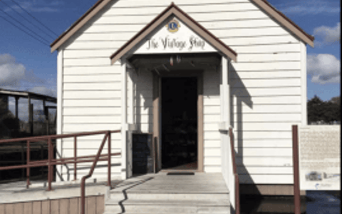 Small white weatherboard building with gable roof and entry steps
