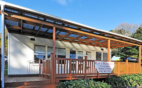 Single-storey pavilion with timber deck and corrugated roof canopy