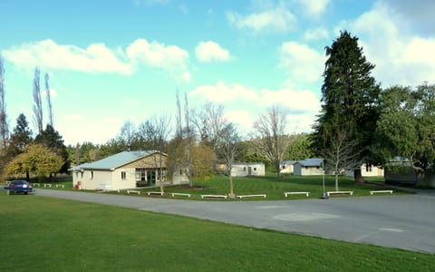 Camp grounds with low buildings, grass lawn and mature trees