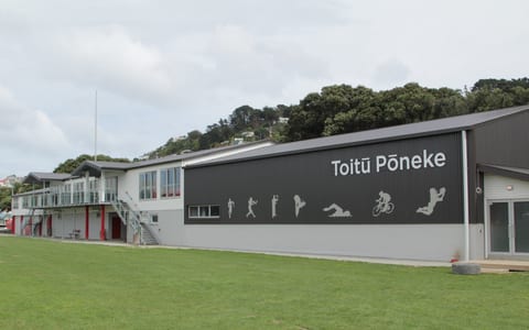 Large sports centre building with Toitu Poneke signage and sports silhouettes