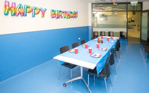 Function room set with table and chairs decorated for a birthday party