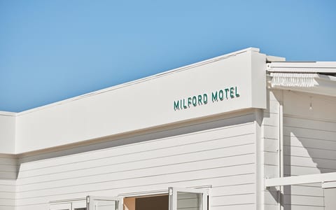 White motel building facade with signage under blue sky