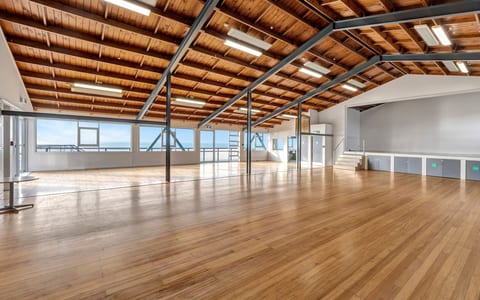 Large open hall with timber ceiling, exposed steel beams and polished wood floors