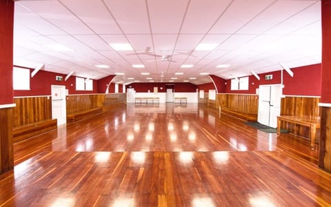 Large empty hall with polished red-brown timber floor, red painted walls, timber wainscoting