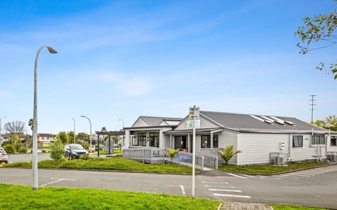 Single-storey community house building with car park and street lighting