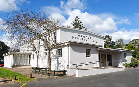White rendered memorial hall with flat roof and name signage