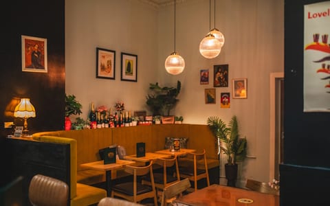 Intimate dining nook with warm pendant lights, booth seating and framed artwork