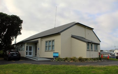 Single-storey hall with weatherboard cladding and gable roof