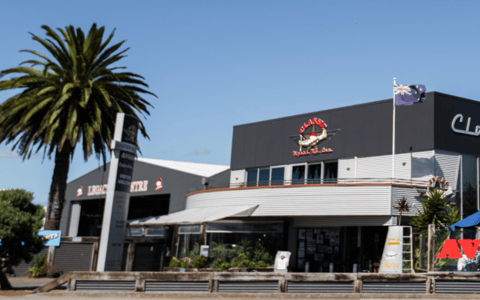 Classic Flyers NZ building exterior with cafe signage and palm trees