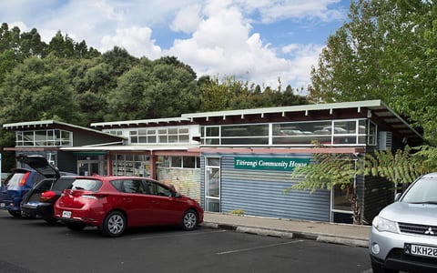 Low-rise community building with signage beside car park