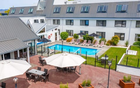 Hotel courtyard with outdoor pool, sun loungers, umbrellas and multi-storey building