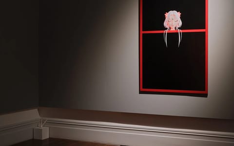 Dark-walled gallery room with single spotlit artwork in red frame, timber floor, ornate cornice