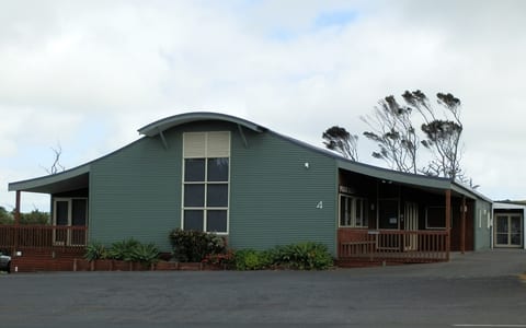Green corrugated iron hall exterior with curved roof and verandah