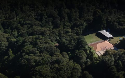 Aerial view of lodge buildings and lawn clearing surrounded by dense bush