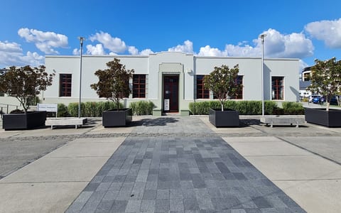 Art deco style building with symmetrical facade and paved forecourt