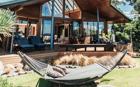 Lodge with distinctive angular timber roof, hammock and timber deck