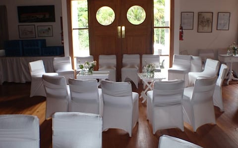 Hall set for a wedding with white chair covers and round porthole doors
