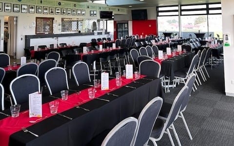 Function room with long tables set in black and red for a dining event