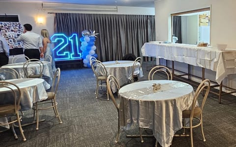 Function room dressed with balloons and round tables for a birthday celebration