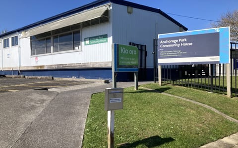 Single-storey community hall exterior with signage and car park