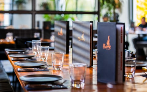 Restaurant dining setup with set table, menus, and large windows