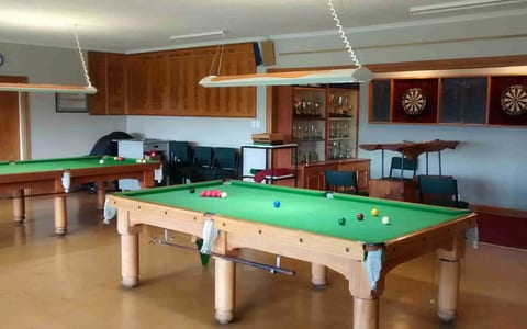 Games room with snooker tables, dartboards and trophy cabinet