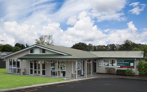 Single-storey community house building with covered entry and signage