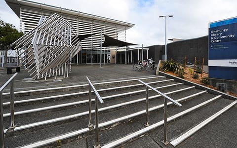 Modern community centre building with angular canopy and entrance steps