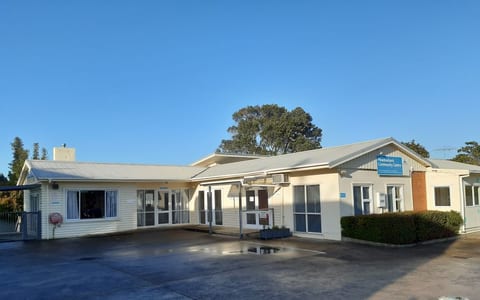 Single-storey community centre building with carpark in morning light