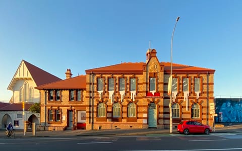 Two-storey red brick heritage building with terracotta roof tiles, street frontage