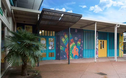 Low-rise building with colourful murals on exterior walls